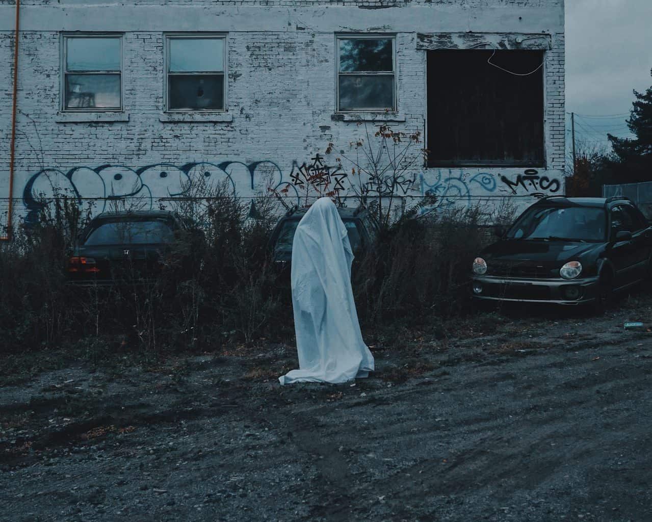 Lady ghost covered with white cloth on am eerie street
