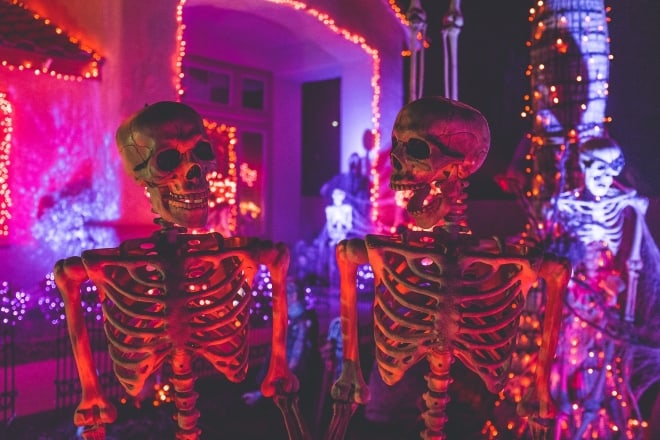 two skeleton near white concrete building - Halloween Party Decorations