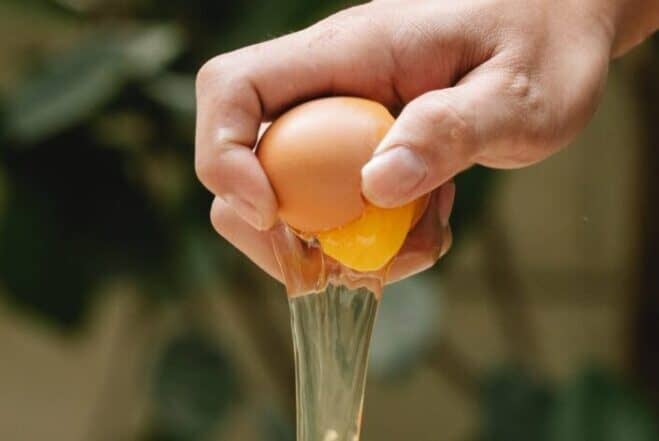 hand breaking an egg - types of eggs