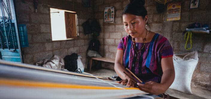 Woman weaving a textile.
