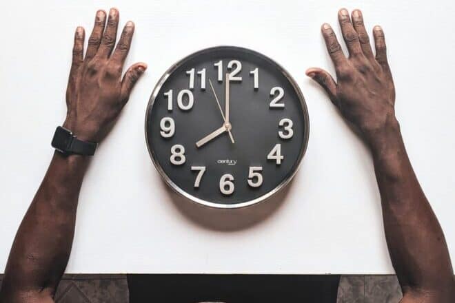black clock in between two hands - types of clocks