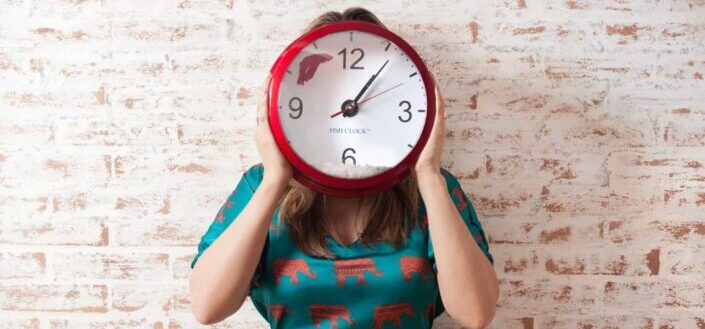 woman covering face her face with a wall timepiece