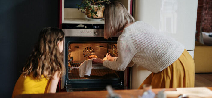 Mom and Daughter Getting Food Out of the Oven