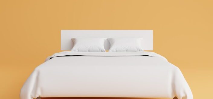 Bed With Bedcover and Pillow on Yellow Background