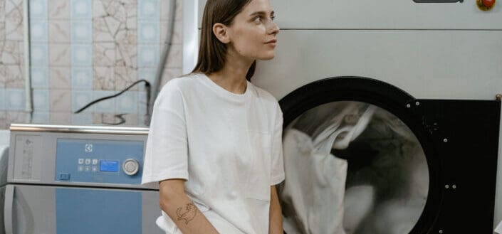 A woman in white shirt leaning on the machine