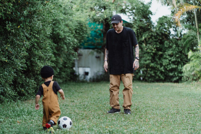 Father and Son Playing Soccer Outside