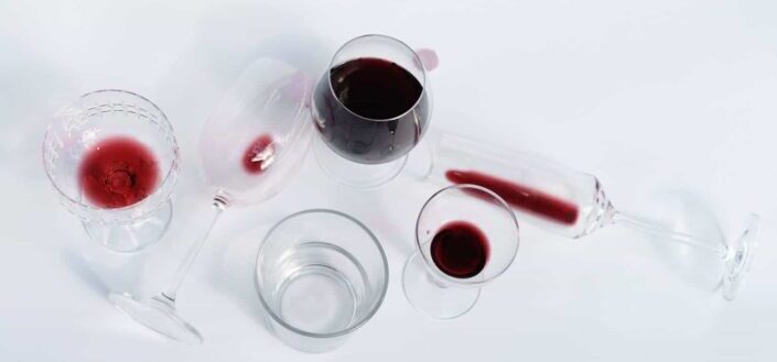 Wineglasses with red wine on white table